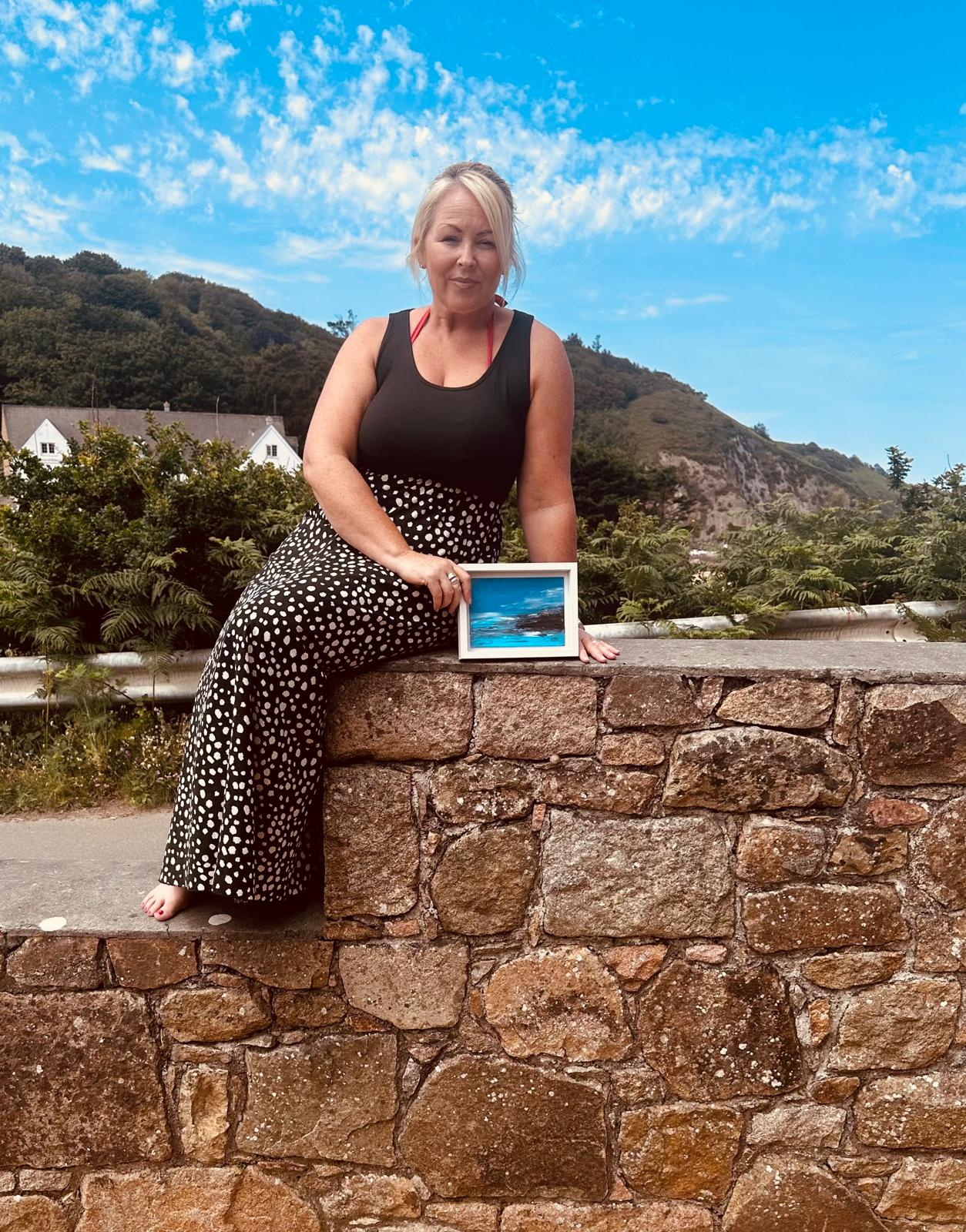 Elizabeth Sarah seated outdoors with original artwork