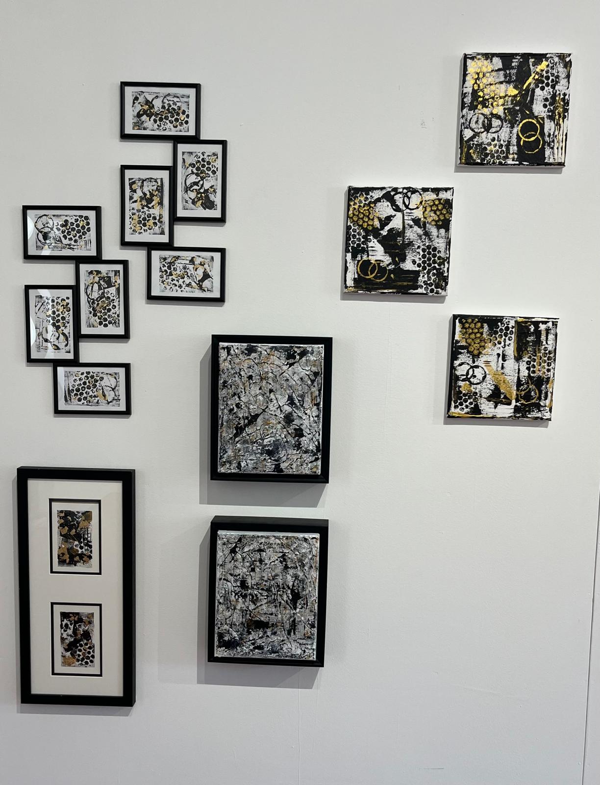 Black, white and gold artworks arranged as a gallery wall